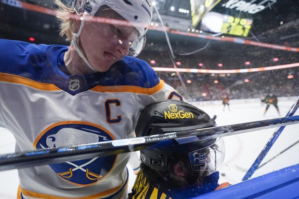 Buffalo Sabres' Rasmus Dahlin, left, checks Vancouver Canucks' Conor Garland during the first period of an NHL hockey game in Vancouver, on Tuesday, Jan. 21, 2025. THE CANADIAN PRESS/Darryl Dyck