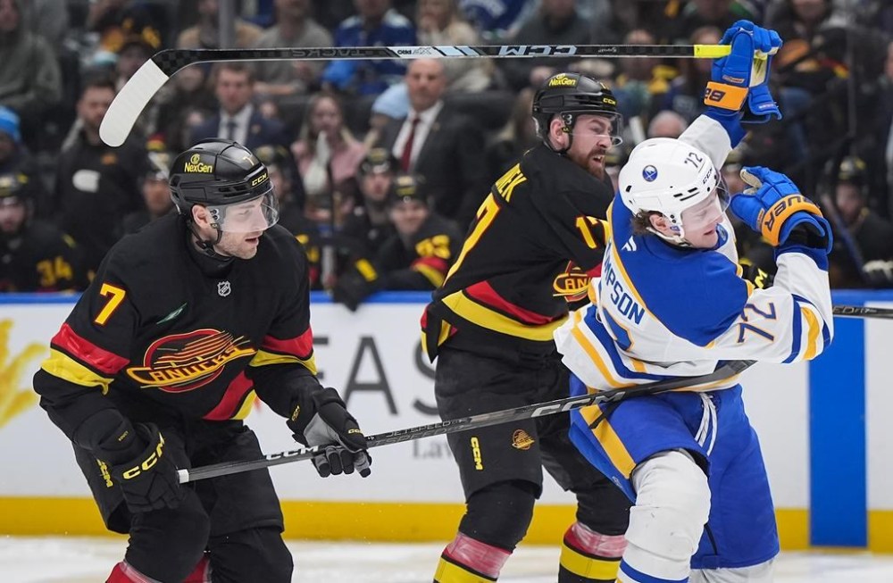 Vancouver Canucks' Carson Soucy (7) hooks Buffalo Sabres' Tage Thompson (72) as he and Vancouver's Filip Hronek, back right, attempt to slow him down during the third period of an NHL hockey game in Vancouver, on Tuesday, Jan. 21, 2025. THE CANADIAN PRESS/Darryl Dyck