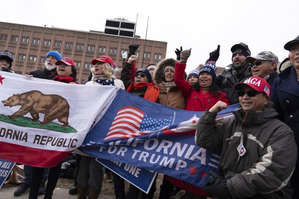Supporters of President Donald Trump stand with their flags in support of people convicted for their part in the Jan. 6 riot at the U.S. Capitol at the DC Central Detention Facility in Washington, Tuesday, Jan. 21, 2025. (AP Photo/Jose Luis Magana)