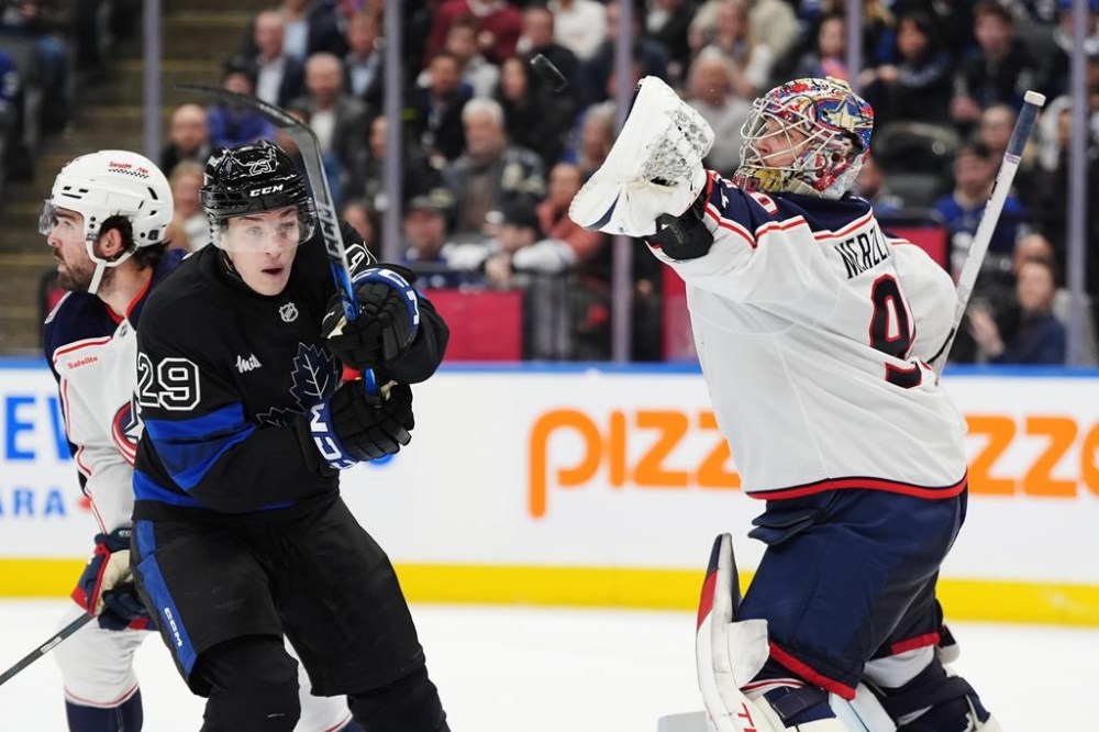 Columbus Blue Jackets goaltender Elvis Merzlikins (90) reaches for the puck in front of Toronto Maple Leafs' Pontus Holmberg (29) during second period NHL hockey action in Toronto on Wednesday, January 22, 2025. THE CANADIAN PRESS/Frank Gunn