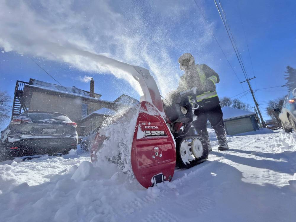 Jocelyn Funk, a.k.a. “The Snow Lady,” uses a gas-powered hand-held snowblower to clean the back lane of a house at the corner of 12th Street and Lorne Avenue on a Monday morning in March. The Brandon resident, who says she “loves to blow snow,” was out volunteering her time in clearing sidewalks and driveways in the downtown area.