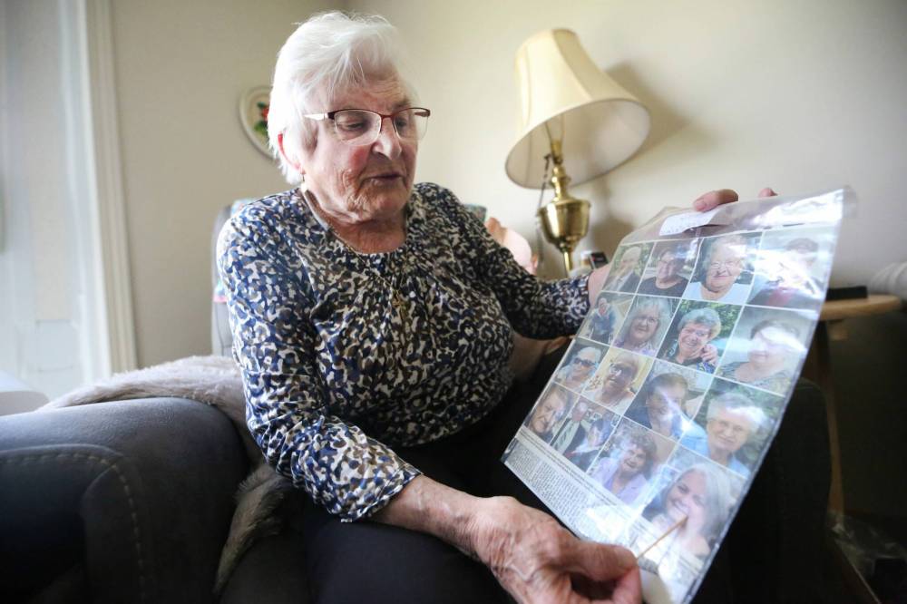 Josephine (Jo) Stokotelny, seen here in her apartment at Loray Manor in Dauphin in June, holds up a copy of the Winnipeg Free Press from 2023 showing the photos of most of the individuals who died as a result of the June 15, 2023 collision near Carberry that claimed the lives of 17 people from the city of Dauphin. Stokotelny says she prays for them every day.