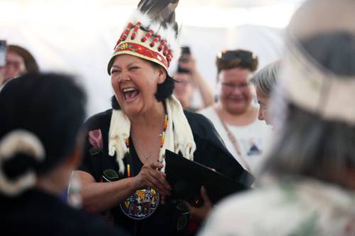 Wearing a ceremonial headdress, Assembly of Manitoba Chiefs Grand Chief Cathy Merrick laughs while taking her oath of office following her first-ballot election victory for the position on July 24 during the 36th Annual General Assembly that was held on Waywayseecappo First Nation land near Brandon. (Photos by Matt Goerzen/The Brandon Sun)