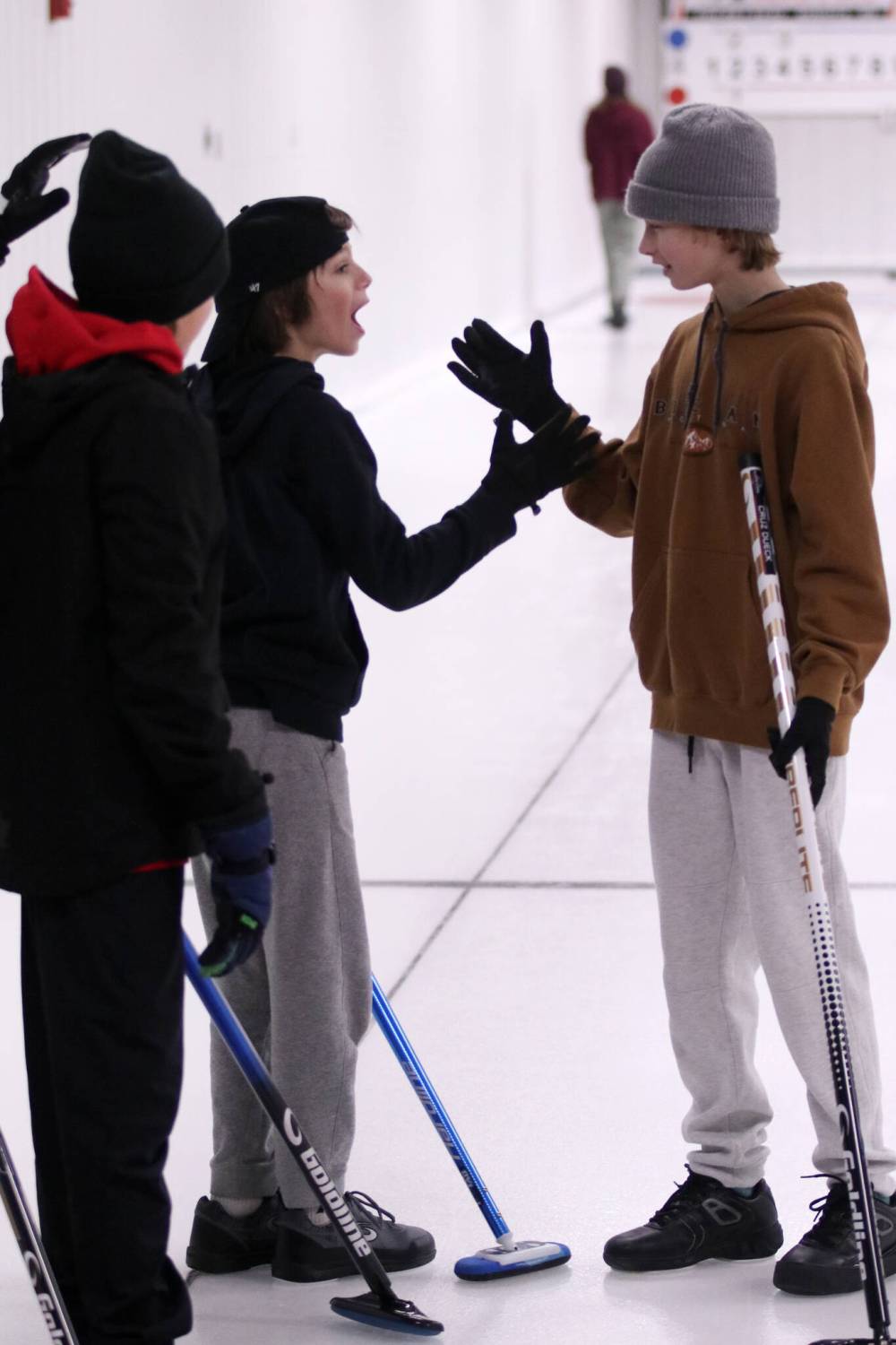 Jaxon Stanley and Cruz Dueck high five each other after picking up a win on Saturday at the Miniota Curling Club. (Matt Packwood/The Brandon Sun)