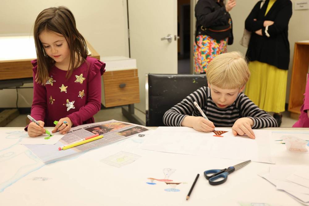 Eloise Dubois (left), 6, and Townes Zacharias, 6, add to the map of Utopia during the Wheat City Nuit Blanche Saturday evening.