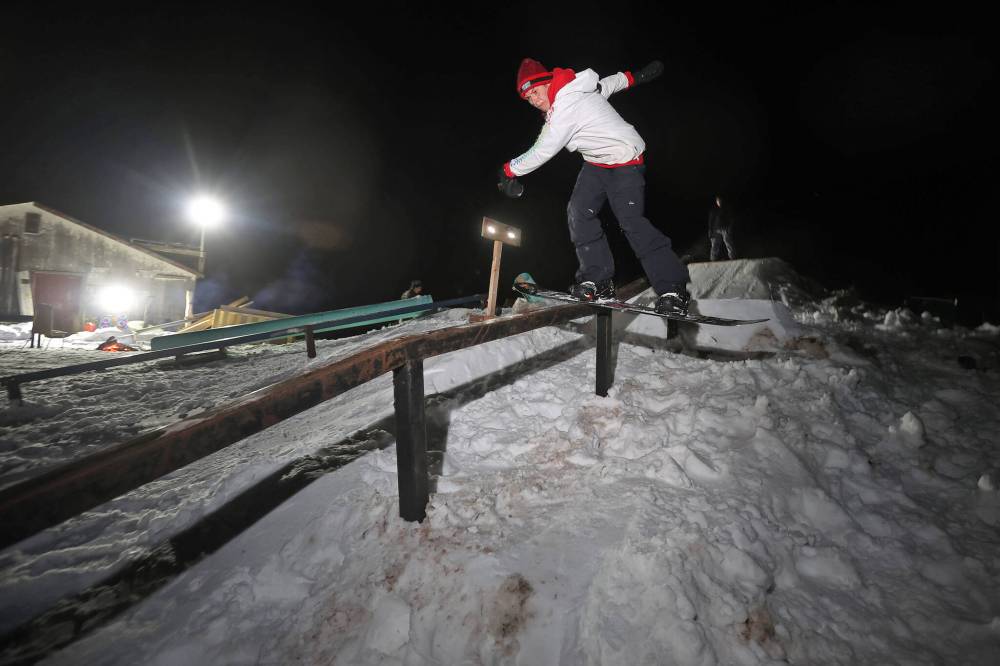 Alex Misanchuk boardslides a rail in the backyard park at Campbell’s home on a mild Wednesday evening. Campbell and friends built the majority of the park before the snow fell, and he and his friends have been riding since the first snowfall.