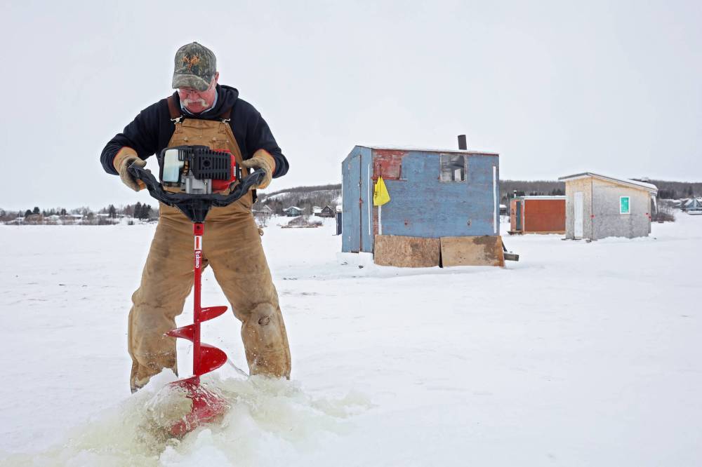 Bryan McFarlane drills a hole in the ice on Minnedosa Lake for a neighbour while ice fishing with his wife Val and friend Ray Morgan on the lake on a mild Thursday. The McFarlanes have had an ice-fishing shack on the lake every year for the last 15 years. They keep track of their days out and how many fish they catch. The most they’ve caught in one day this year is 12 fish, most of which they release back into the lake.