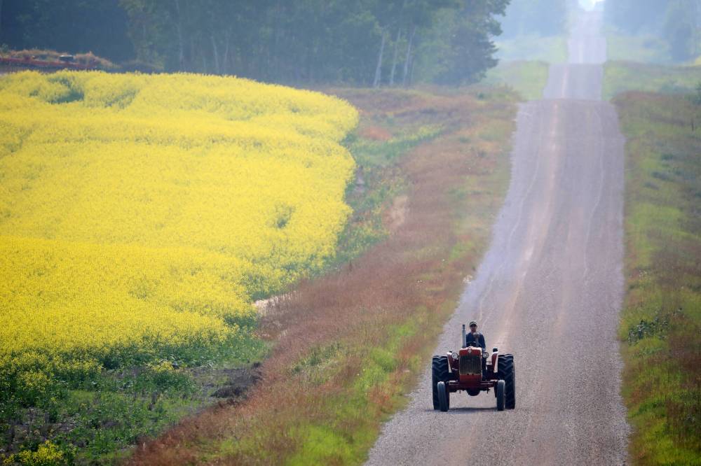 A farmer rides a tractor along a grid road south of Erickson. (Tim Smith/The Brandon Sun files)