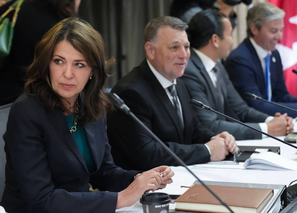 Alberta premier Danielle Smith, left, talks with colleagues during the fall meetings of Canada’s premiers hosted by Ontario, in Toronto on Dec. 16. Smith is the lone premier dissenter in Canada’s “Team Canada” approach to U.S. President Donald Trump’s tariff threat. (The Canadian Press)