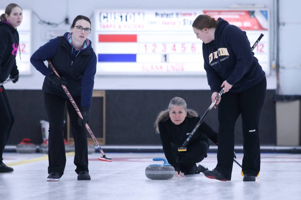 Theresa Payette throws as rock as Kelsey Crandall and Jennah Dersken prepare to sweep in the women's A-side final. (Matt Packwood/The Brandon Sun)