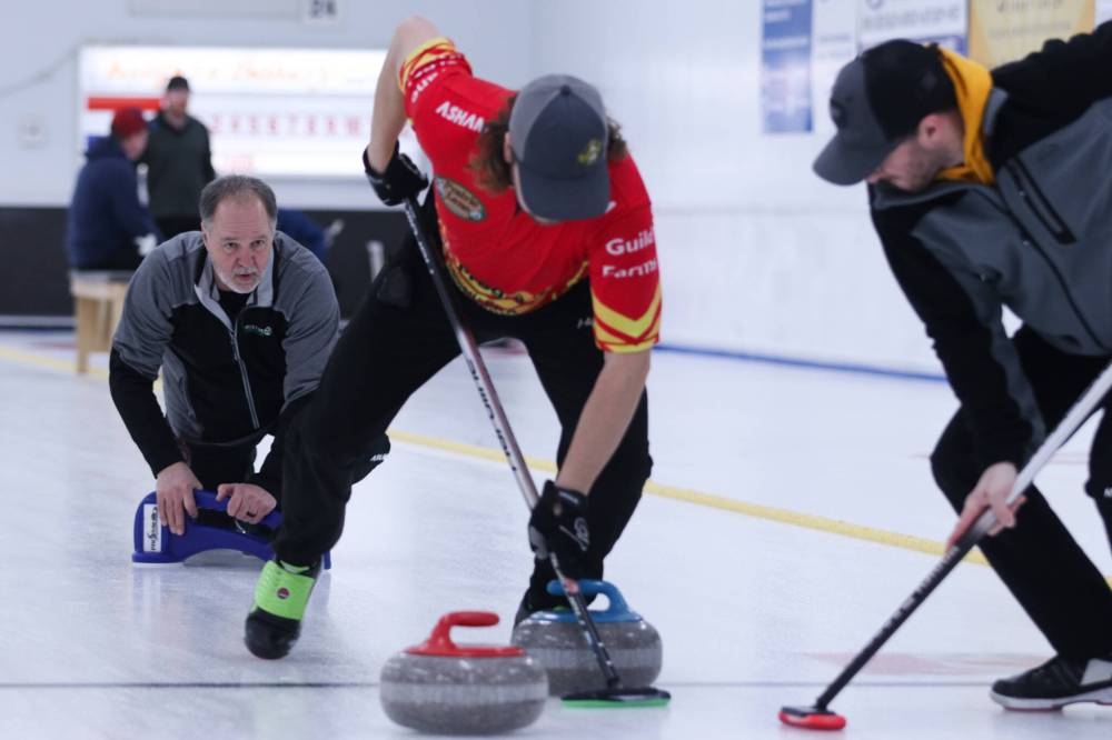 Allan West looks on as his sweepers help a rock into position in the men's A-side final on Sunday. (Matt Packwood/The Brandon Sun)