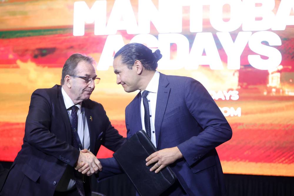 Manitoba Premier Wab Kinew shakes hands with Agriculture Minister Ron Kostyshyn after speaking during the dignitaries address at Manitoba Ag Days on Tuesday. (Tim Smith/The Brandon Sun)