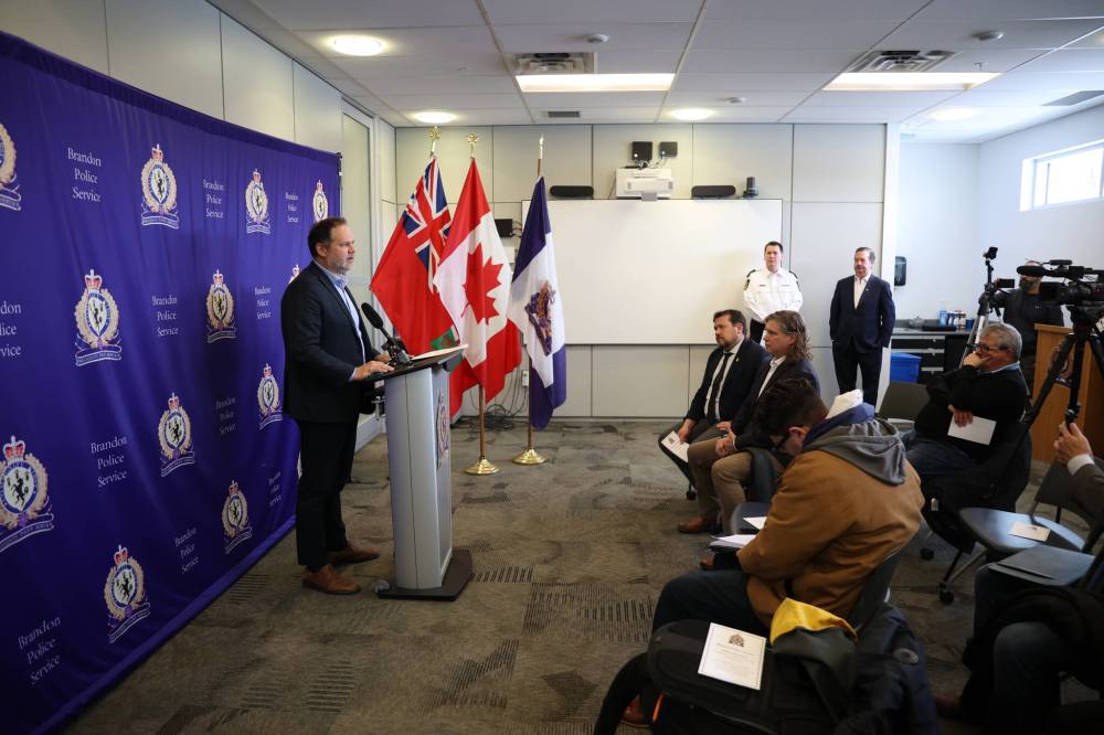 Justice Minister Matt Wiebe speaks during a press conference at the Brandon Police Service (BPS) headquarters about recent efforts targeting retail theft in the city. Also seen in the photo (seated, from right to left) are Brandon Mayor Jeff Fawcett, Brandon East MLA and minister for municipal and northern relations, francophone affairs and Manitoba Liquor and Lotteries Glen Simard, (standing, left to right) BPS Chief Tyler Bates and Glenn Butt with Canadian Tire. (Tim Smith/The Brandon Sun)