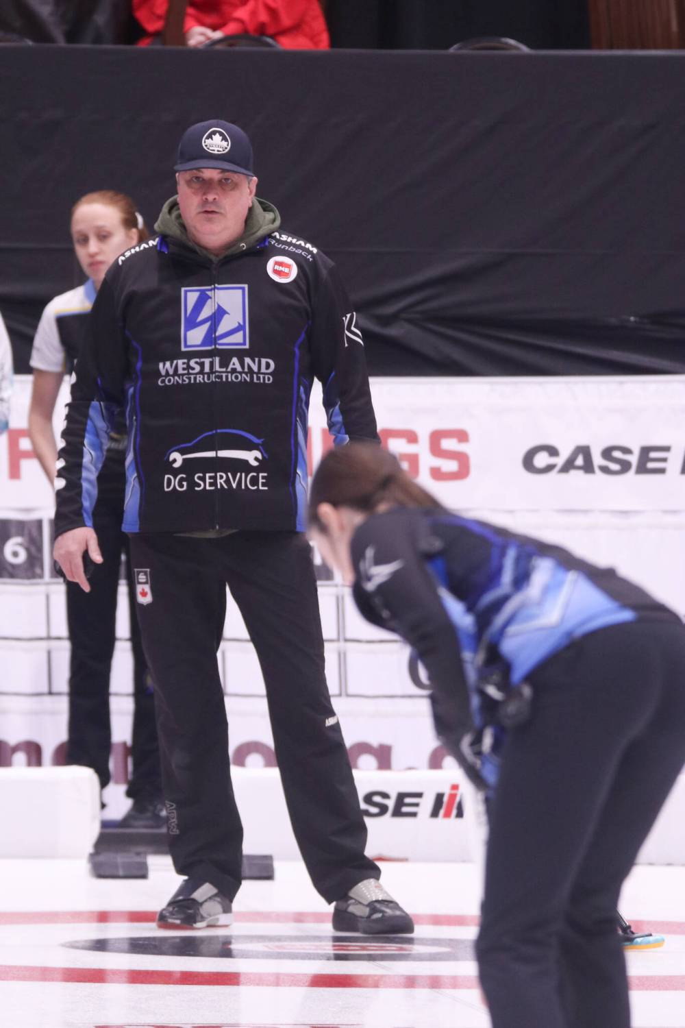 Coach William Lyburn looks on as daughter Mikaylah sweeps practice rocks ahead of the team’s opening draw.