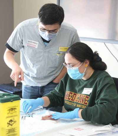 Prairie Mountain Health chief medical officer Dr. Adrian Fung (left) is a family physician and anesthetist. He is seen instructing a University of Manitoba medical student on how to properly suture a wound during a past Rural Interest Group (RIG) initiative that was held at the Brandon Regional Health Centre. (The Brandon Sun Files)