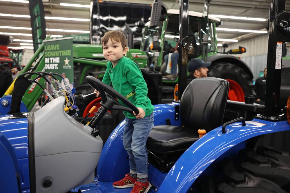 Teddy Thompson, 3, plays atop a New Holland tractor on display during Manitoba Ag Days at the Keystone Centre on Wednesday. (Tim Smith/The Brandon Sun)