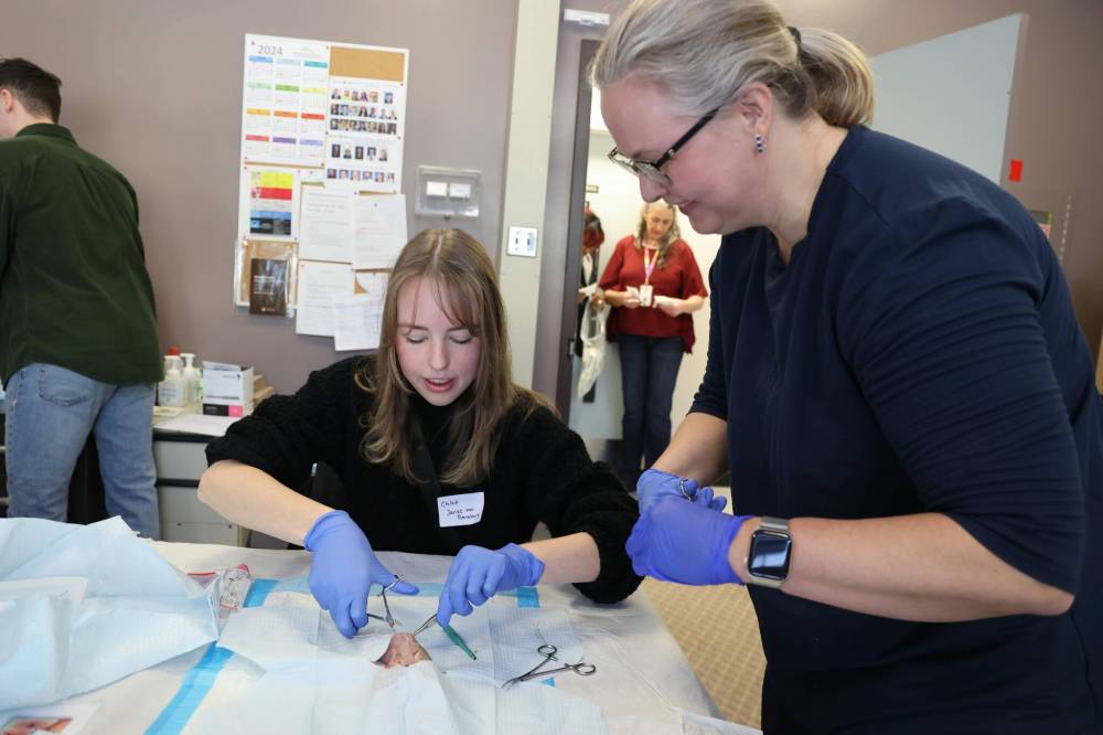 University of Manitoba Rural Interest Group (RIG) medical student Chloe Janse van Rensburg (left) practises suturing with pork while her mother, Dr. Erika Molle, who is a family physician in oncology in Brandon, supervises her during a tour by medical students of the Brandon Regional Health Centre on Saturday morning. (Abiola Odutola/The Brandon Sun)