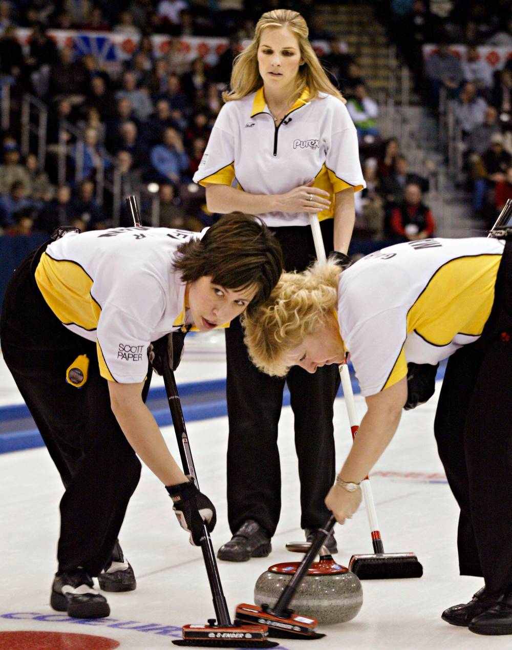 Manitoba skip Jennifer Jones looks on as second Jill Officer, left, and lead Cathy Gauthier sweep at the Scott Tournament of Hearts women's curling championship final in St. John's in 2005. The team went on to win their first of many championships together. (Canadian Press files)