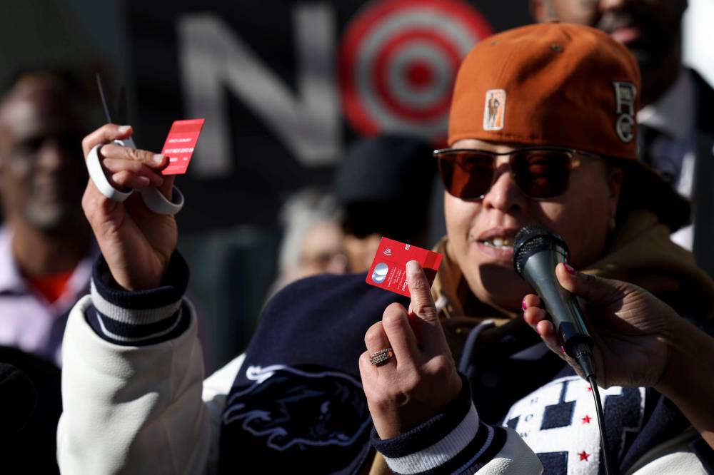 A community advocate cuts a Target credit card during a news conference outside Target Corporation’s headquarters in Minneapolis on Thursday. Civil rights activists have called for a Target boycott after the retailer backed away from its diversity, equity and inclusion (DEI) programs. (The Associated Press)