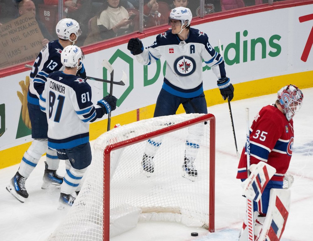 Winnipeg Jets' Mark Scheifele (55) celebrates his goal over Montreal Canadiens goaltender Sam Montembeault (35) with teammates Kyle Connor (81) and Gabriel Vilardi (13) during second period NHL hockey action in Montreal on Tuesday, Jan. 28, 2025. THE CANADIAN PRESS/Christinne Muschi