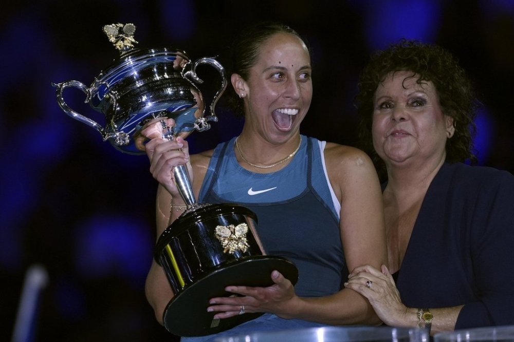 Madison Keys, center, of the U.S. reacts as she receives the the Daphne Akhurst Memorial Cup from Evonne Goolagong Cawley after defeating Aryna Sabalenka of Belarus in the women's singles final at the Australian Open tennis championship in Melbourne, Australia, Saturday, Jan. 25, 2025. (AP Photo/Ng Han Guan)