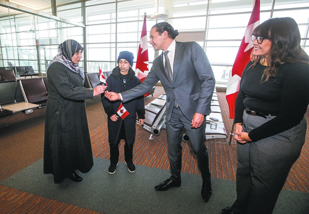 Premier Wab Kinew and his wife, Lisa Monkman, welcome a Palestinian mother and her son from Gaza at the Winnipeg airport on Thursday. The province is hosting the mother and her son and providing complex health care for the boy. (The Canadian Press)