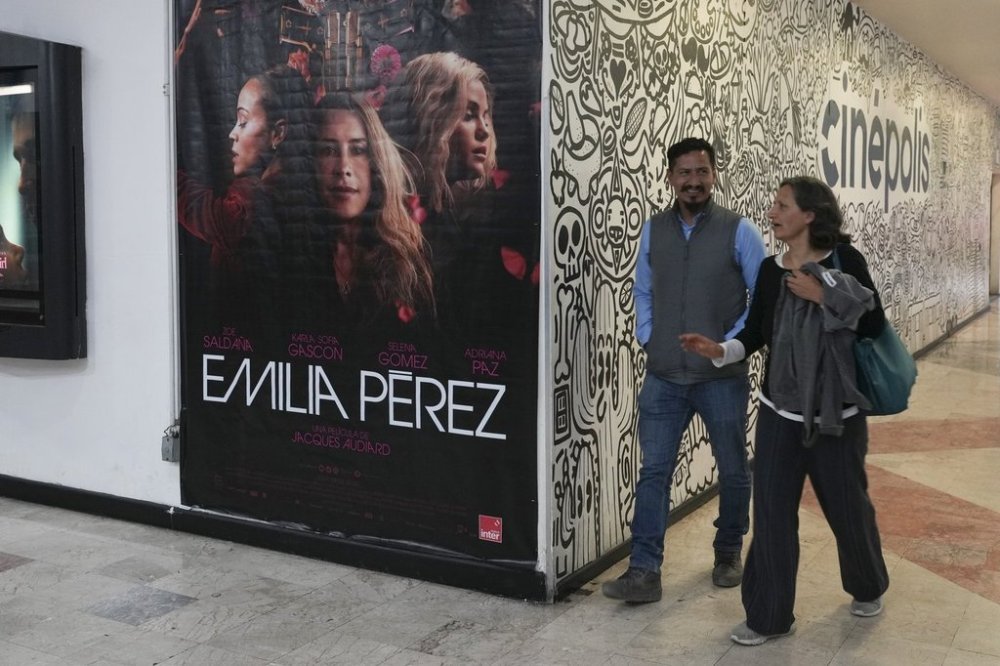 People walk past an advertisement for the film Emilia Perez at a movie theater in Mexico City, Thursday, Jan. 23, 2025. (AP Photo/Marco Ugarte)