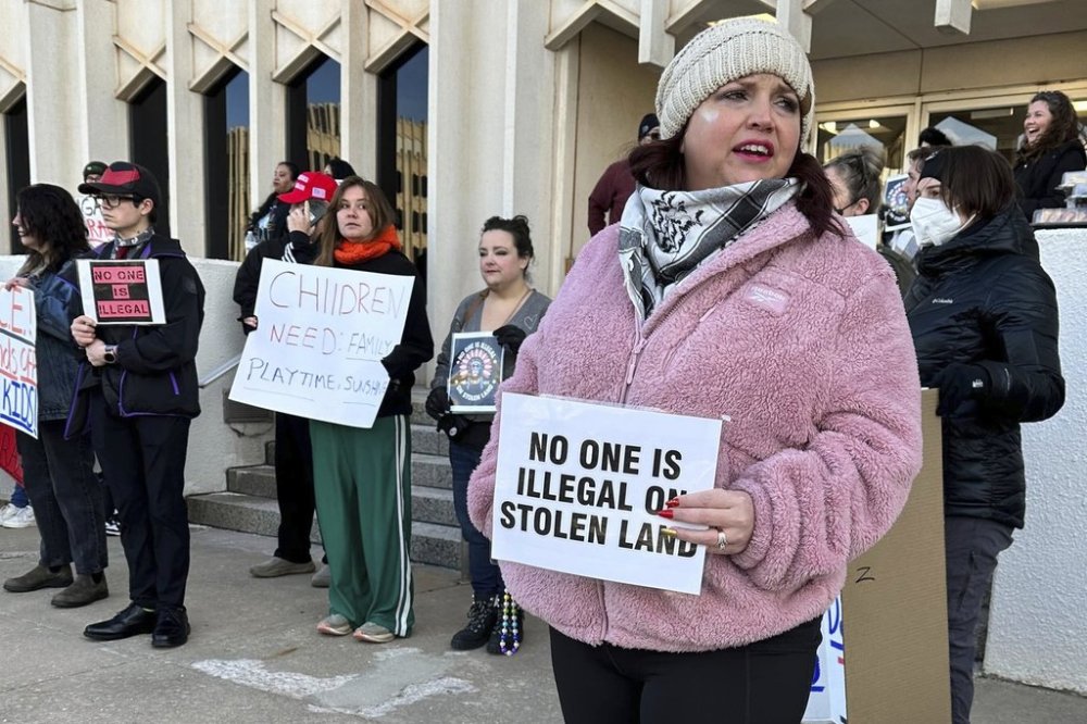 Erica Watkins of Tulsa, state director of Defense of Democracy holds a sign to protest Oklahoma's Board of Education considering a rule that would require parents enrolling children in public schools to provide proof of their child's U.S. citizenship or legal immigration status on Tuesday, Jan. 28, 2025 in Oklahoma City, Oka. (AP Photo/Sean Murphy)