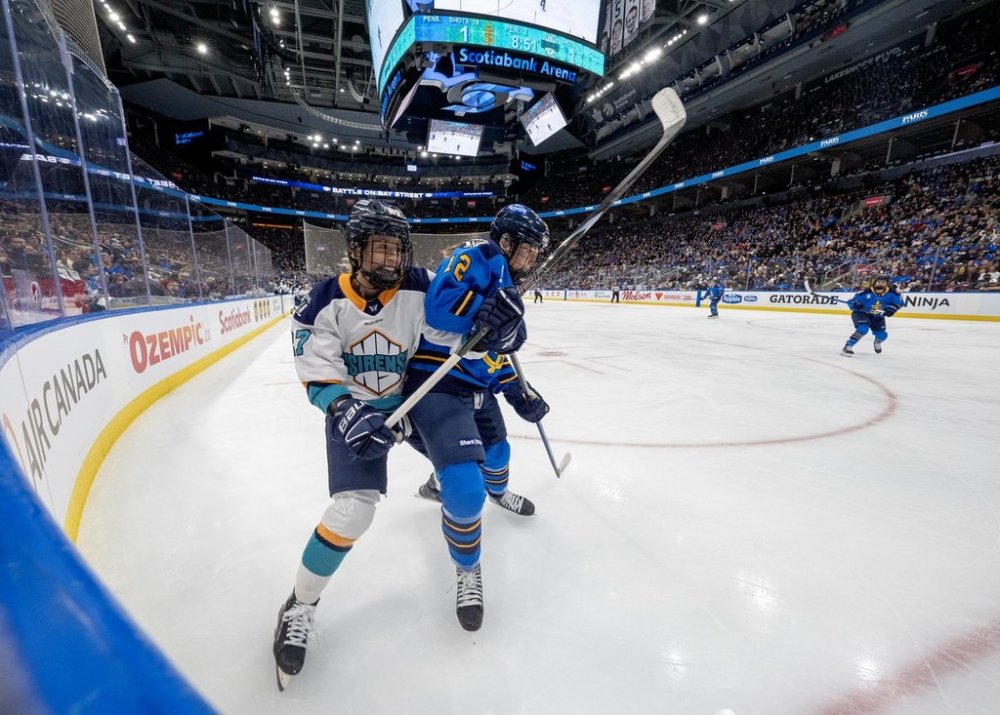 New York Sirens' Jade Downie-Landry (27) and Toronto Sceptres' Allie Munroe (12) battle for position in sold out Scotiabank Arena during second period PWHL hockey action in Toronto on Saturday January 25, 2025. THE CANADIAN PRESS/Frank Gunn