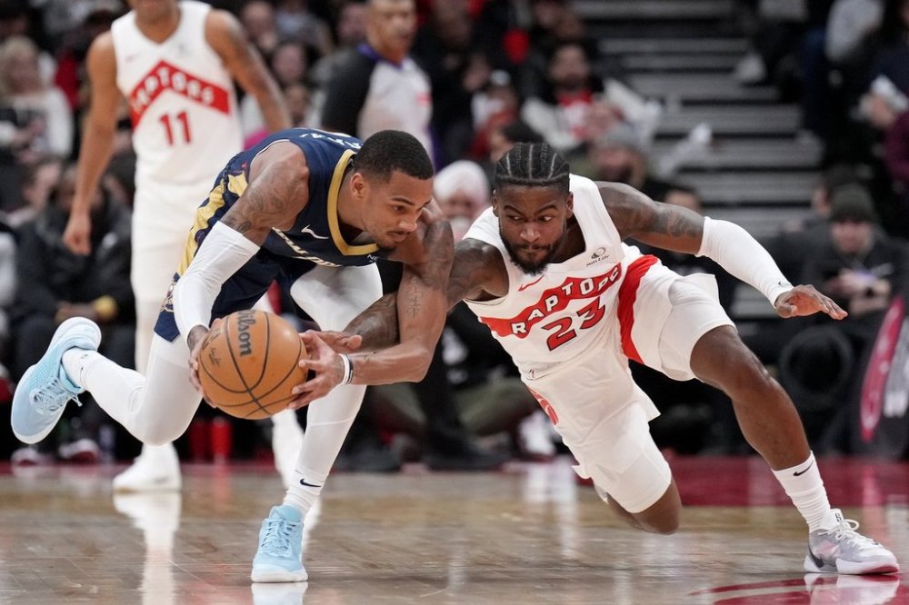 Toronto Raptors guard Jamal Shead (23) battles with New Orleans Pelicans guard Dejounte Murray (5) for control of the ball during second half NBA basketball action in Toronto on Monday, Jan. 27, 2025. THE CANADIAN PRESS/Nathan Denette