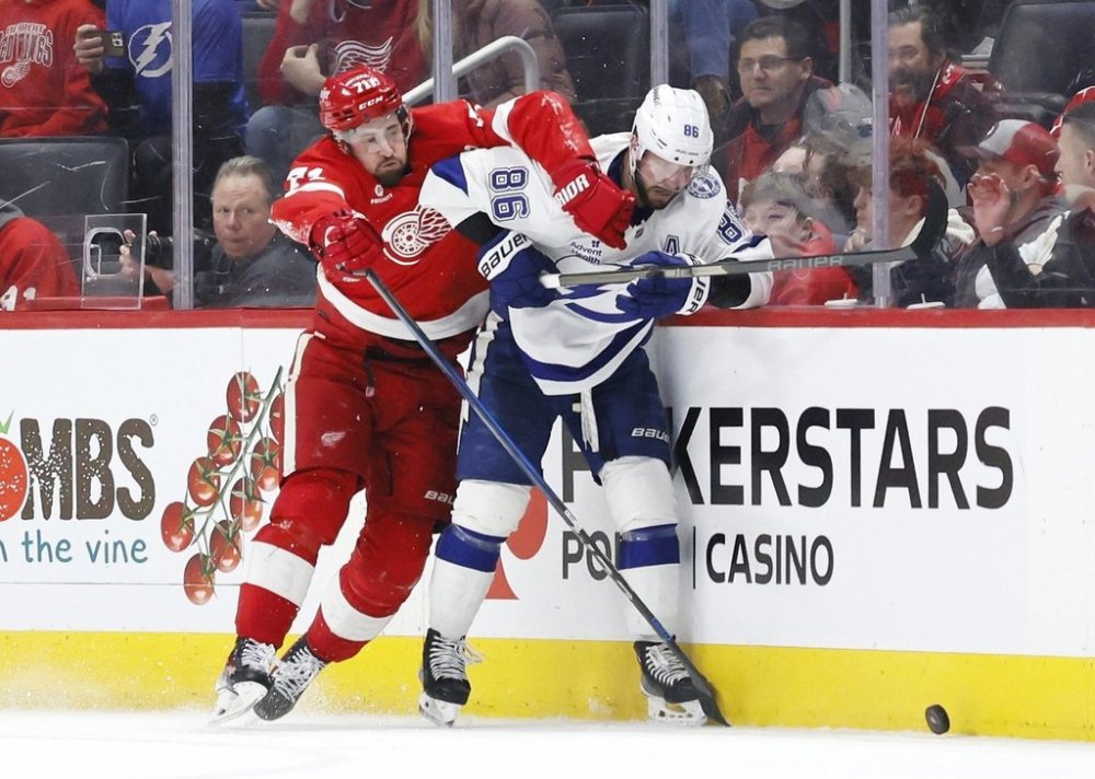 Tampa Bay Lightning right wing Nikita Kucherov (86) is check against the boards by Detroit Red Wings centre Dylan Larkin, left, during the third period of an NHL hockey game Saturday, Jan. 25, 2025, in Detroit. (AP Photo/Duane Burleson)