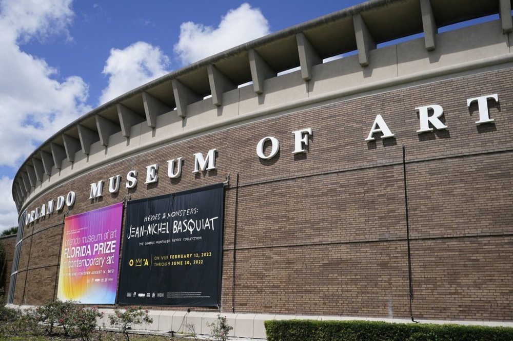 FILE - A banner advertising an exhibit by artist Jean-Michel Basquiat hangs from the exterior of the Orlando Museum of Art, where a collection of Basquiat's paintings were on display, June 2, 2022, in Orlando, Florida. (AP Photo/John Raoux, File)