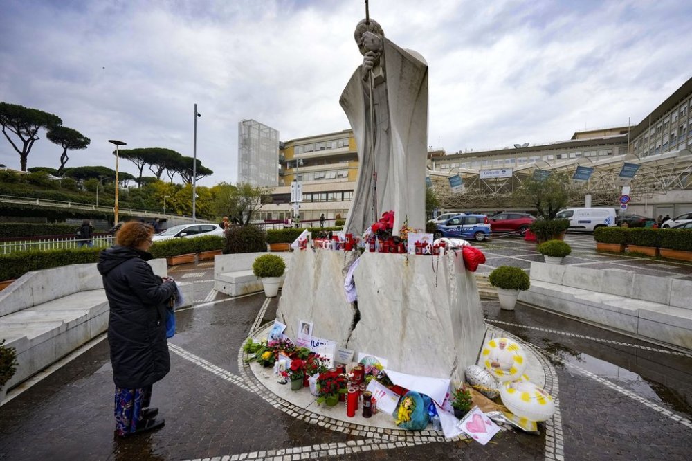 A woman prays for Pope Francis in front of the Agostino Gemelli Polyclinic, in Rome, where the Pontiff has been hospitalized since Feb. 14, Wednesday, Feb. 26, 2025. (AP Photo/Andrew Medichini)