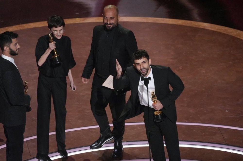 Basel Adra, from left, Rachel Szor, Hamdan Ballal, and Yuval Abraham accept the award for best documentary feature film for
