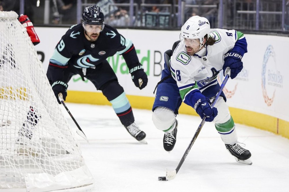 Vancouver Canucks right wing Conor Garland (8) moves the puck against Seattle Kraken centre Chandler Stephenson (9) during third period NHL hockey action, in Seattle, Saturday, March 1, 2025. Rio Giancarlo