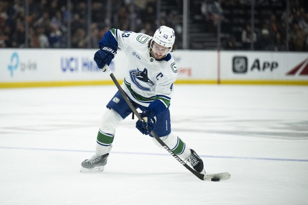 Vancouver Canucks defenceman Quinn Hughes (43) shoots during an NHL hockey game against the Anaheim Ducks, Thursday, Feb. 27, 2025, in Anaheim, Calif. (AP Photo/Kyusung Gong)