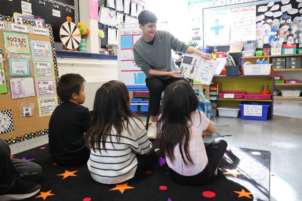 Alex Appleby, a first-year faculty of education student at Brandon University, reads to Grade 3 students at Earl Oxford School on Tuesday. (Tim Smith/The Brandon Sun)