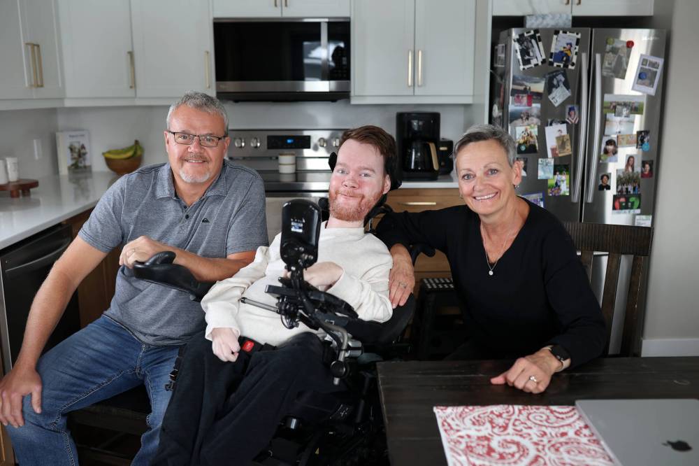 Jeremy Bray (middle) and his parents, Darren and Tara Bray, are shown at their home in Rivers. Jeremy, who’s 29, lives with spinal muscular atrophy, a neurodegenerative disorder that causes the loss of motor neurons and progressive muscle wasting. There is no cure, but there are treatments that slow the progression. His family is hoping the provincial government will cover the treatment. (Photos by Tim Smith/The Brandon Sun)