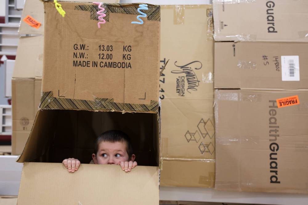 Coven Lougheed, 4, of the YMCA South Early Learning Centre, peers out of a cardboard creation while taking part in the Cardboard Box Challenge on Friday morning.