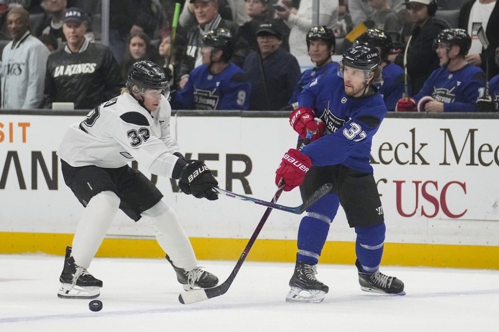 Team Blue player actor Taylor Kitsch passes the puck against Team White player actor and singer Ross Lynch during the Skate for L.A. Strong celebrity hockey game, Sunday, Feb. 23, 2025, in Los Angeles. (AP Photo/Eric Thayer)