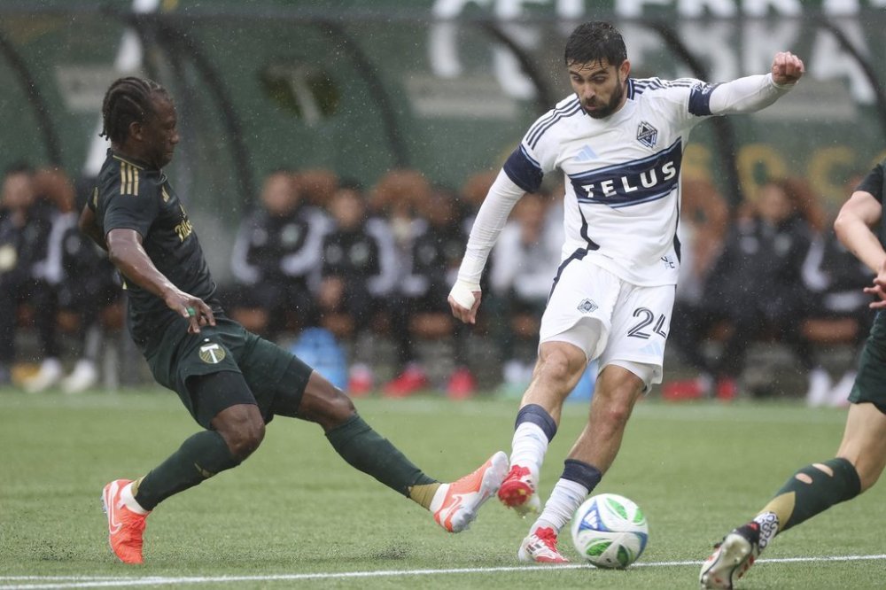 Portland Timbers midfielder Diego Chará, left, and Vancouver Whitecaps forward Brian White, right, fight for possession during an MLS soccer game Sunday, Feb. 23, 2025, in Portland, Ore. THE CANADIAN PRESS/AP-Amanda Loman