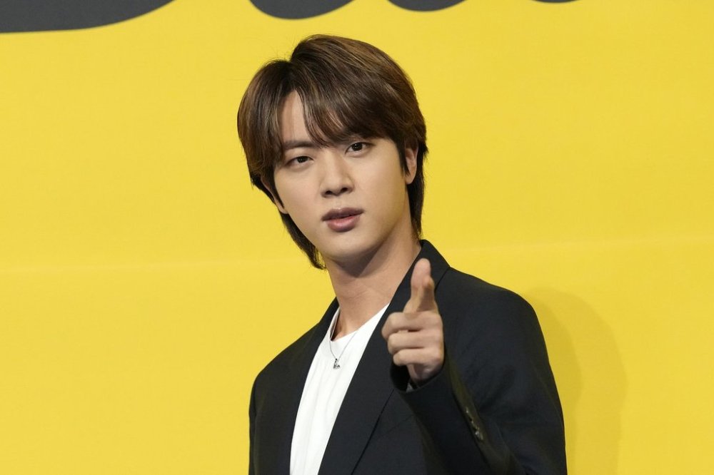 FILE - Jin, a member of South Korean K-pop band BTS, poses for photographers ahead of a press conference to introduce their new single
