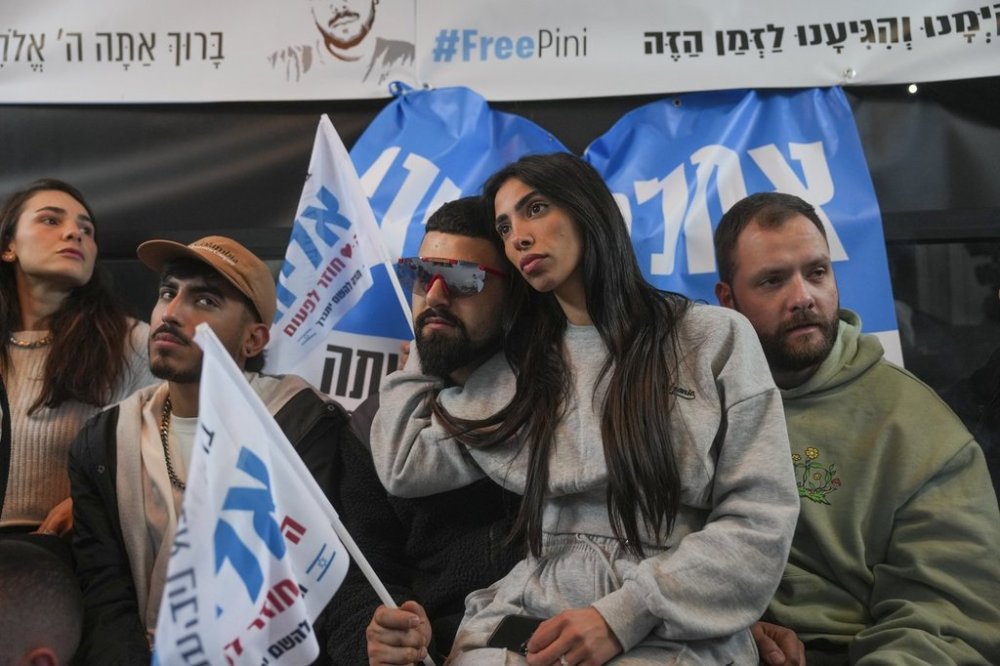 Relatives and friends of Eliya Cohen, 27, gather to watch the TV broadcast of his release by Palestinian militants in Gaza, in Tel Aviv, Israel, Saturday Feb. 22, 2025. (AP Photo/Ohad Zwigenberg)