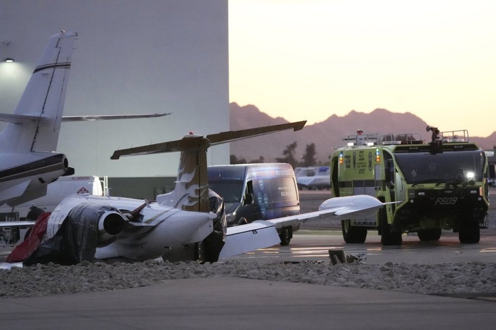 A crashed Learjet sits next to a plane it collided with as Scottsdale Airport Fire Deapartment vehicle sits nearby at Scottsdale Airport Monday, Feb. 10, 2025, in Scottsdale, Ariz. (AP Photo/Ross D. Franklin)