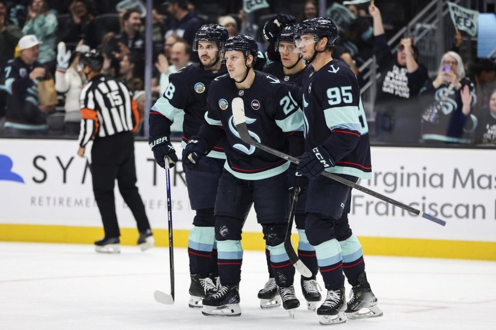 Seattle Kraken right wing Eeli Tolvanen, centre, reacts with teammates defenceman Joshua Mahura and left wing Andre Burakovsky (95) after scoring during the second period of an NHL hockey game against the Vancouver Canucks, Saturday, March 1, 2025, in Seattle. (AP Photo/Rio Giancarlo)