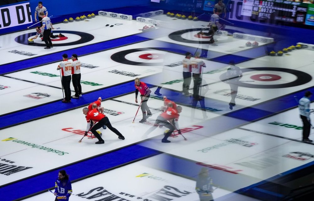 Reflected in a window of an arena suite; Canada second E.J. Harnden and third Mark Nichols, centre left, sweep as lead Geoff Walker watches his shot while playing Prince Edward Island during the Brier, in Regina, on Wednesday, March 6, 2024. The equipment technology tension that has engulfed the elite curling scene in recent weeks is expected to be put on hold at the Montana's Brier. THE CANADIAN PRESS/Darryl Dyck
