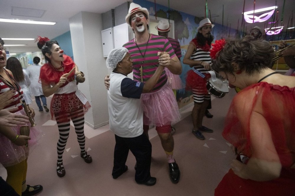 A hospital worker dances with a clown from the