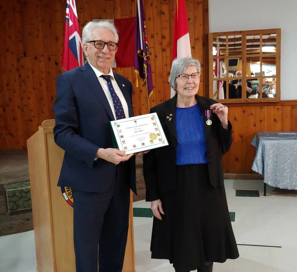 Brandon-Souris Conservative MP Larry Maguire (left) holds a certificate while Sylvia Barr shows off her medallion at Brandon's Army and Navy Hall on Monday. Barr and 29 other western Manitobans will receive the King Charles III Coronation Medal during ceremonies this week. (Submitted)