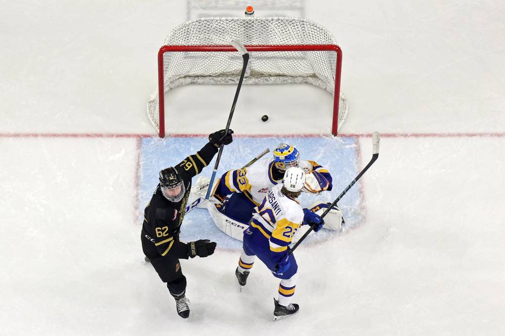 Nicholas Johnson of the Brandon Wheat Kings raises his stick to celebrate a goal by teammate Marcus Nguyen as the puck passes goalie Ethan McCallum of the Saskatoon Blades during WHL action at Westoba Place on Wednesday evening. (Tim Smith/The Brandon Sun)