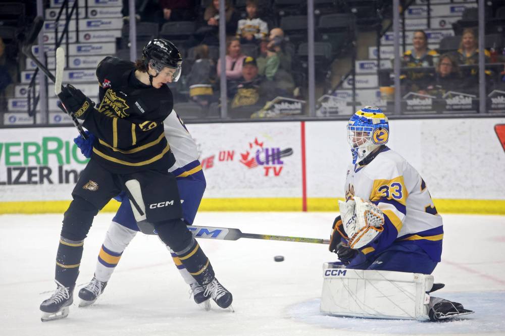Brandon’s Carter Klippenstein looks for the loose puck in front of goalie Ethan McCallum. (Tim Smith/The Brandon Sun)